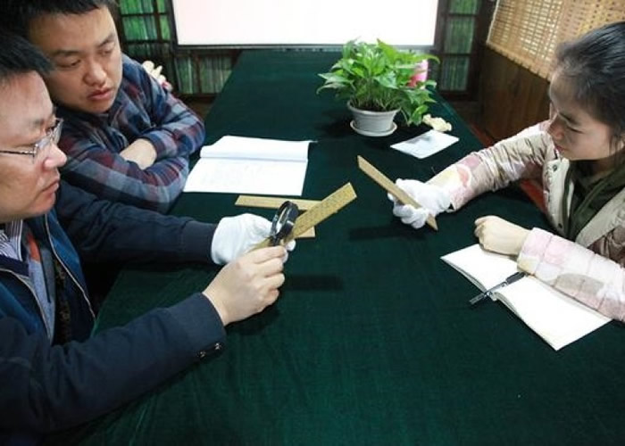 考古学者研究木简上的文字。